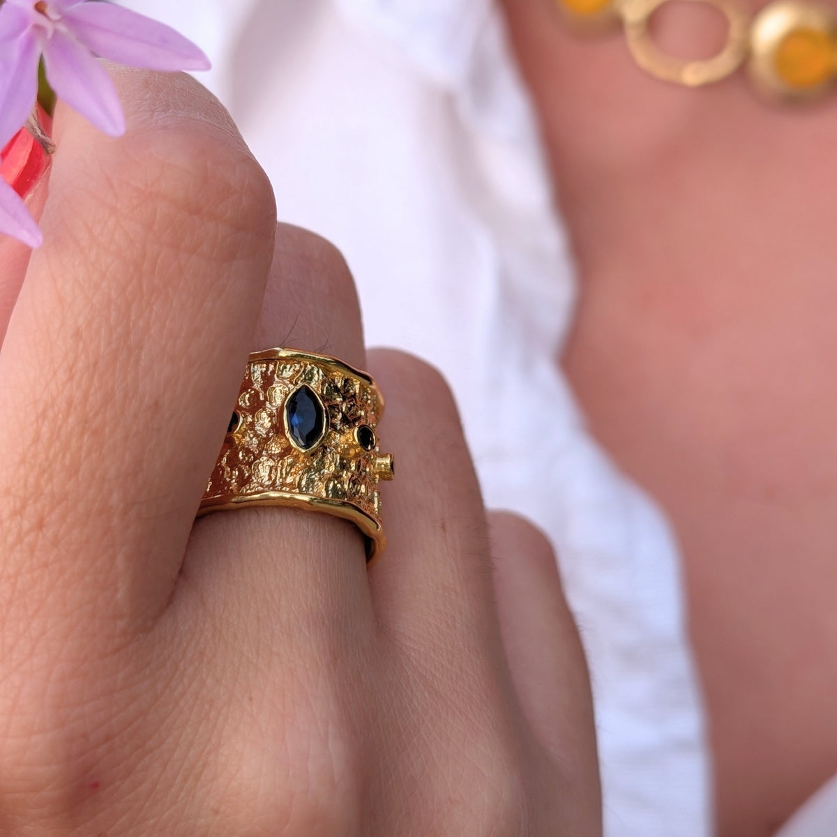 Detalle del anillo Neptuno de AMANAI con piedra azul talla marquesa sobre latón texturizado bañado en oro