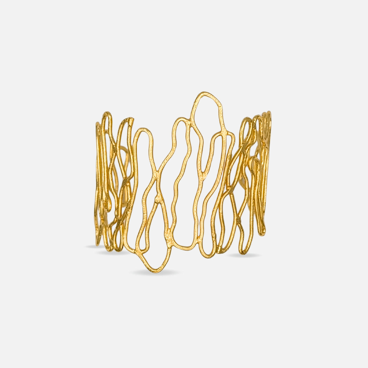 Brazalete Senda de AMANAI, brazalete ancho dorado abierto bañado en oro de 18k con diseño calado de líneas onduladas y acabado texturizado