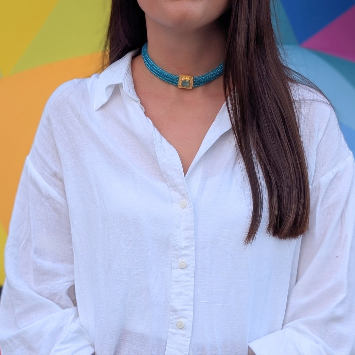 Mujer con choker de varias vueltas de cuentas turquesa y detalle dorado de AMANAI