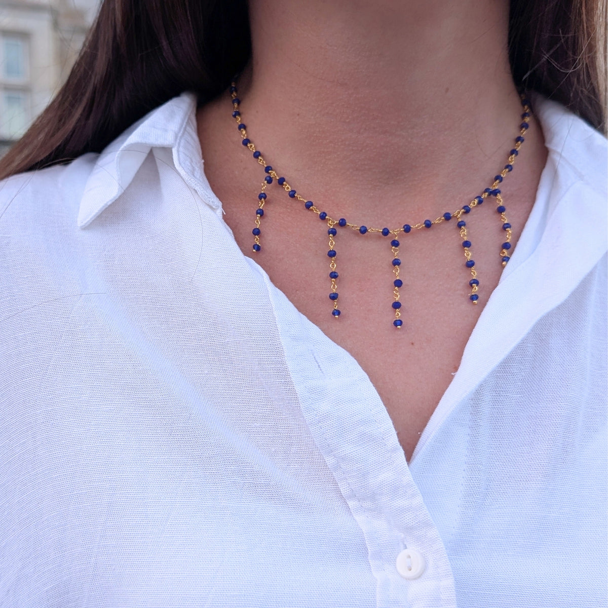 Detalle del collar de AMANAI con cuentas de piedra natural azul y cadena bañada en oro de 18 quilates
